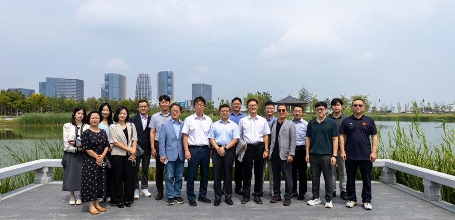 Members of the Korean business delegation posing for a group photograph beside Xiong’an’s green urban landscape